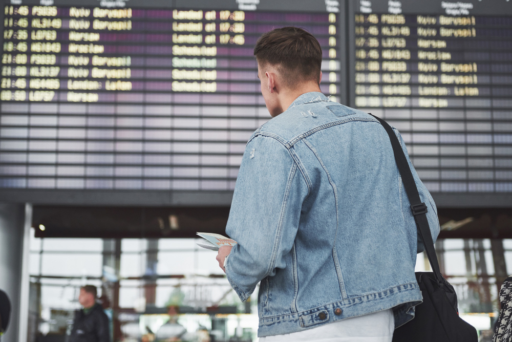 Pasager în aeroport verificând panoul după întârzierea unui zbor
